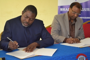 ZUNMO President Fray Michelo (left) with TAU Z Vice Chancellor Prof. (Dr.) Ajay Kumar Poddar signing the MOU between the two institutions, at ZUNMO Headquarters in Lusaka.